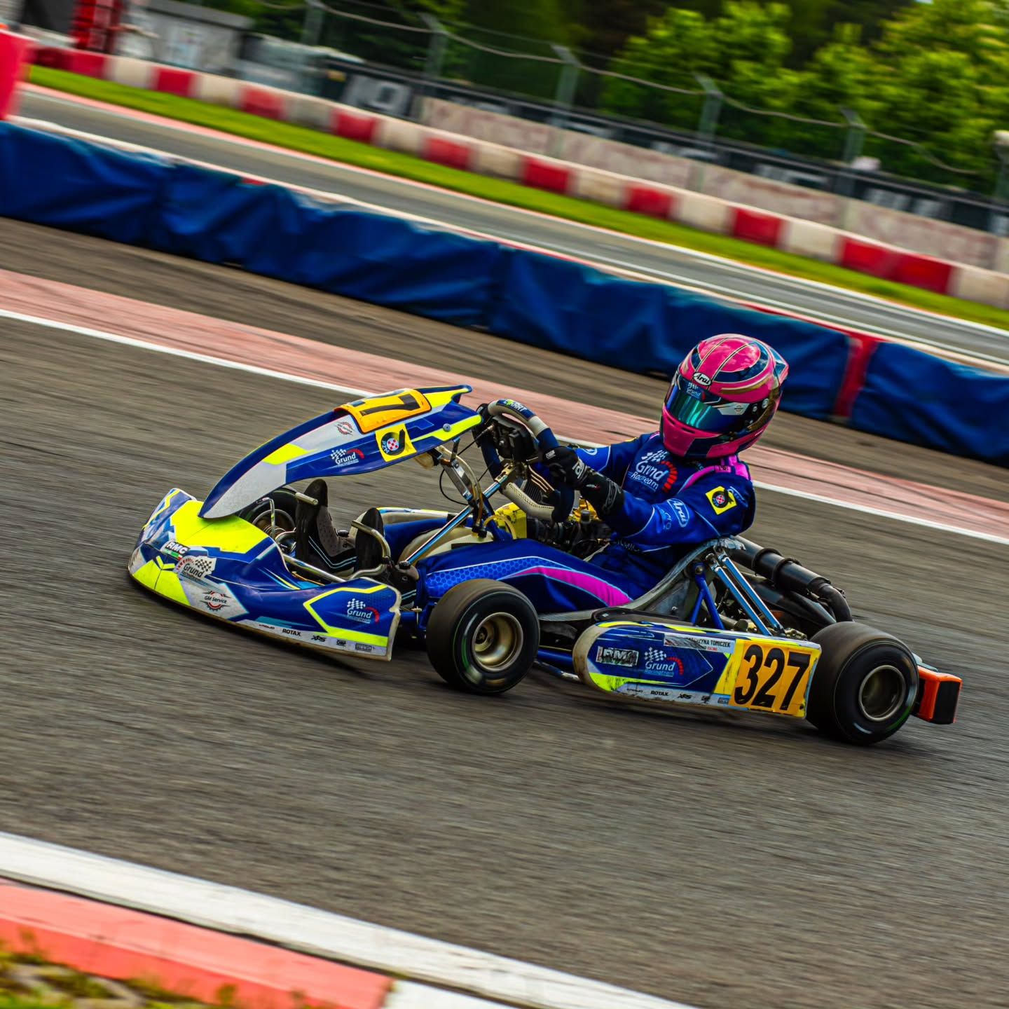 Gokart w zakręcie, kierowca w różowym kasku