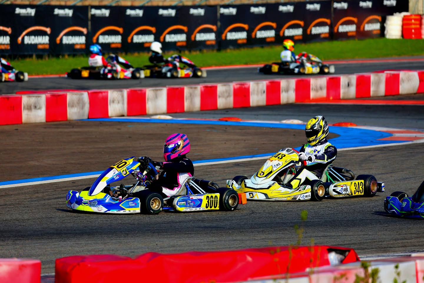 Gokart z numerem 300 w zakręcie, za nim żółty gokart